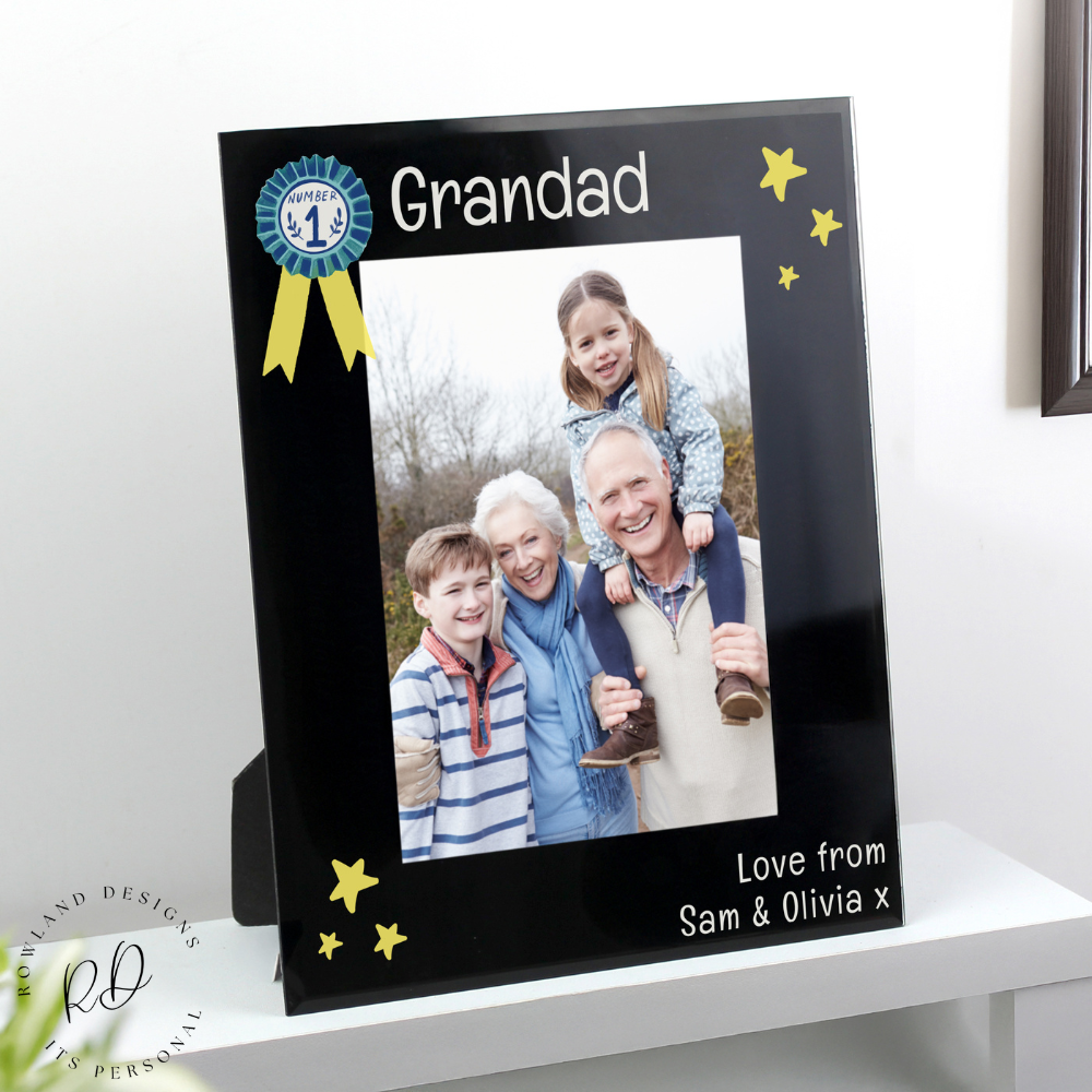 Elegant 5x7 black glass photo frame with a rosette emblem, perfect for personalisation and memorable gifts.