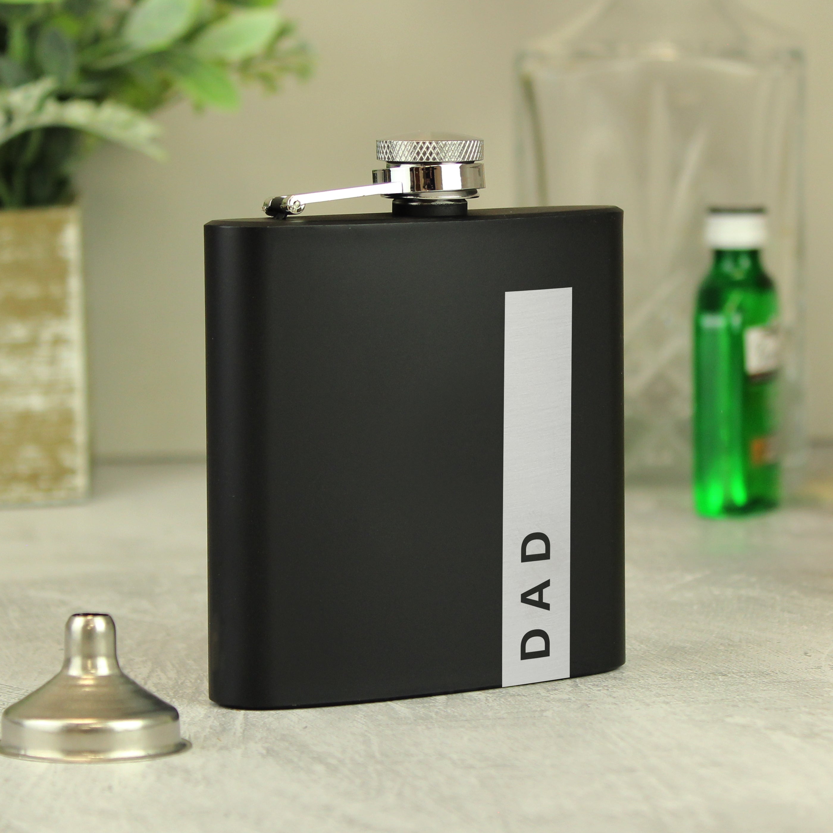 Close-up of the personalised engraving on the black hip flask.