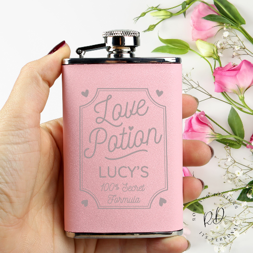 Close-up of personalised name engraving on pink hip flask.