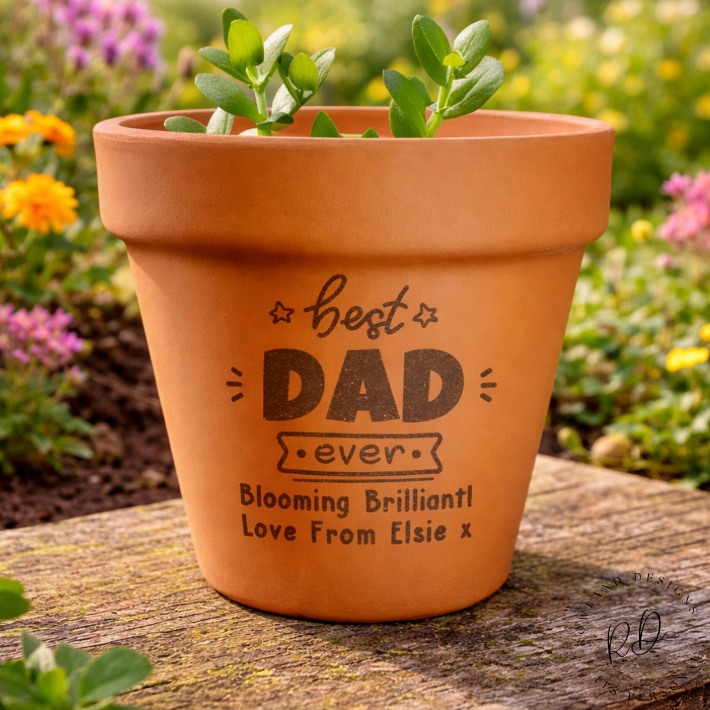 Terracotta pot with engraved message on a wooden surface with a garden background