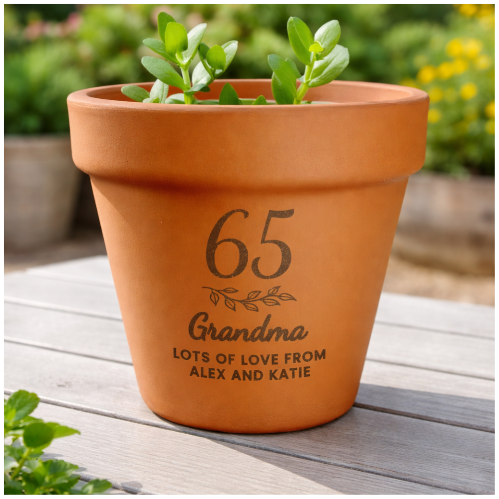Terracotta pot with engraved text on a wooden surface