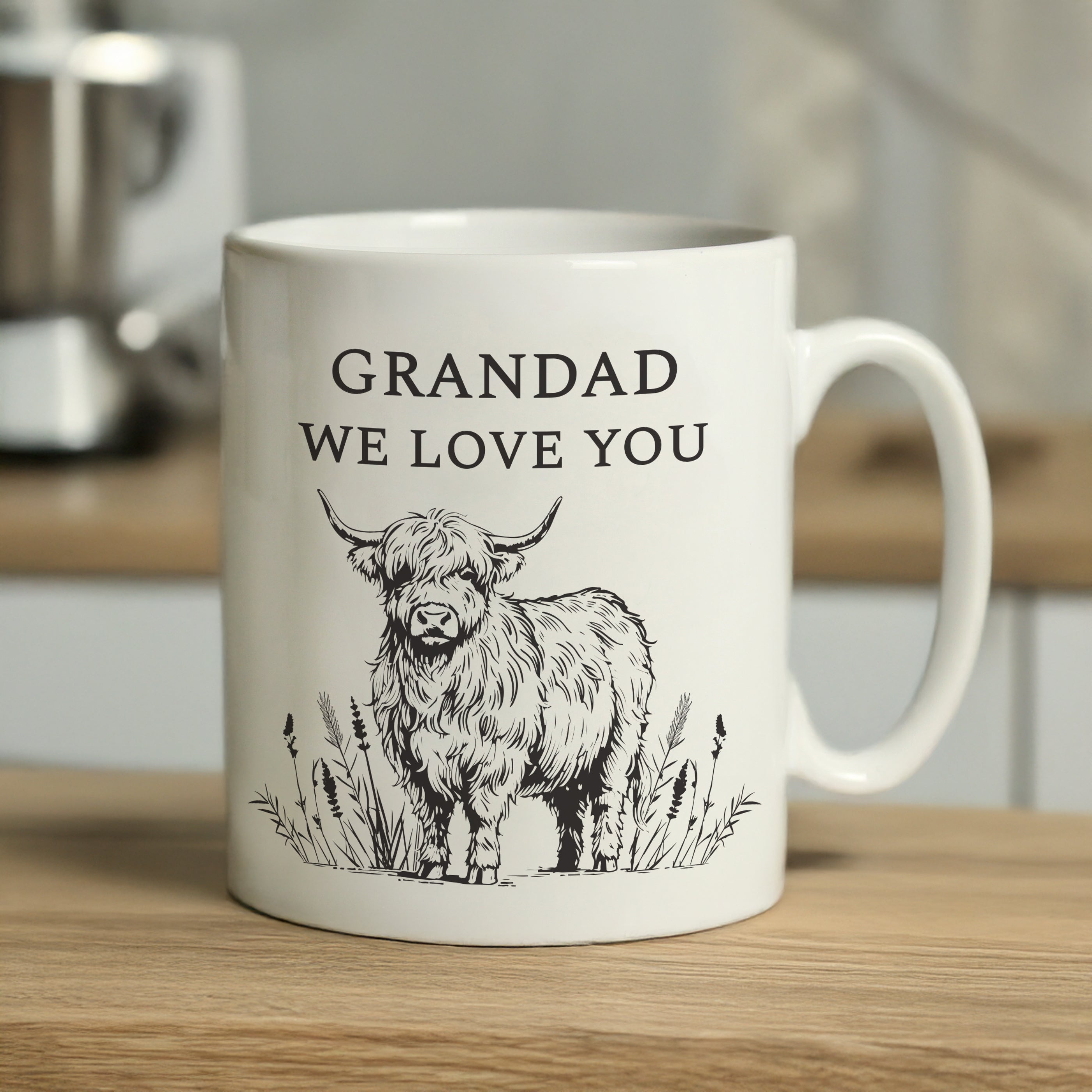 White mug with a highland cow illustration and text on a wooden surface.