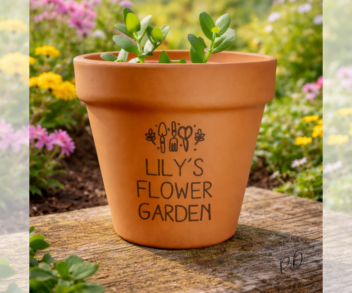 Terracotta pot with 'Lily's Flower Garden' text on a wooden surface with a garden background.