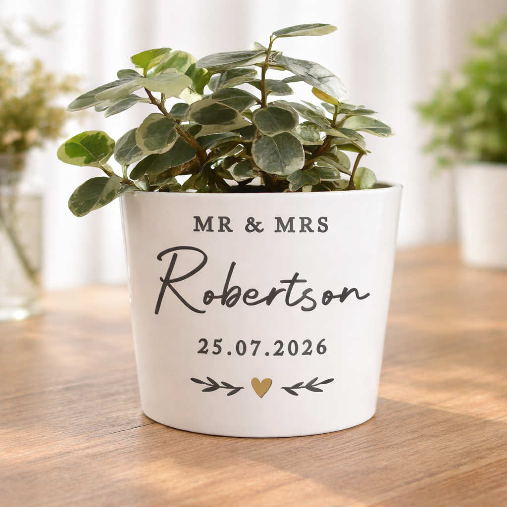 Potted plant with personalized pot on a wooden surface