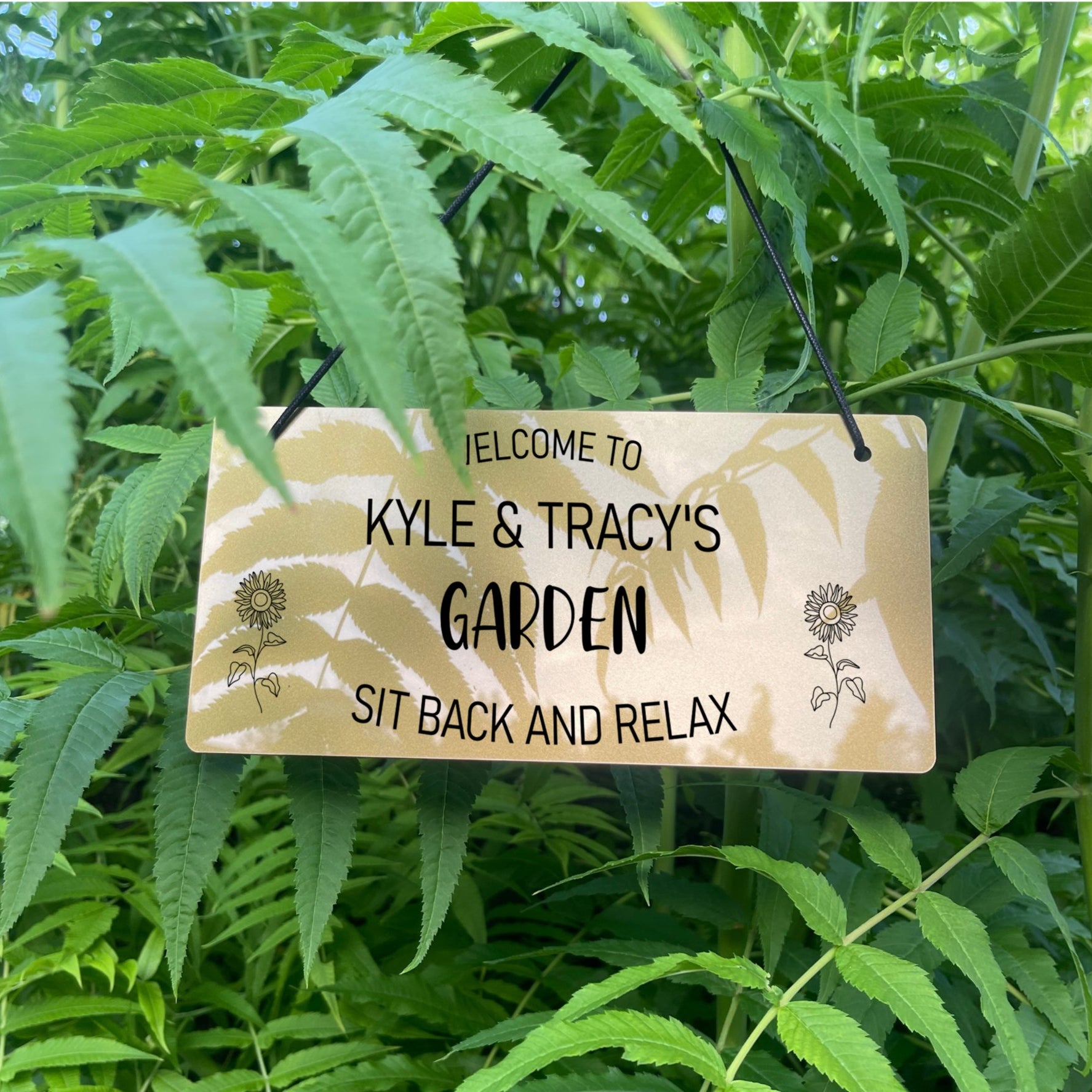 Detailed close-up of sunflower engraving on acrylic welcome sign.