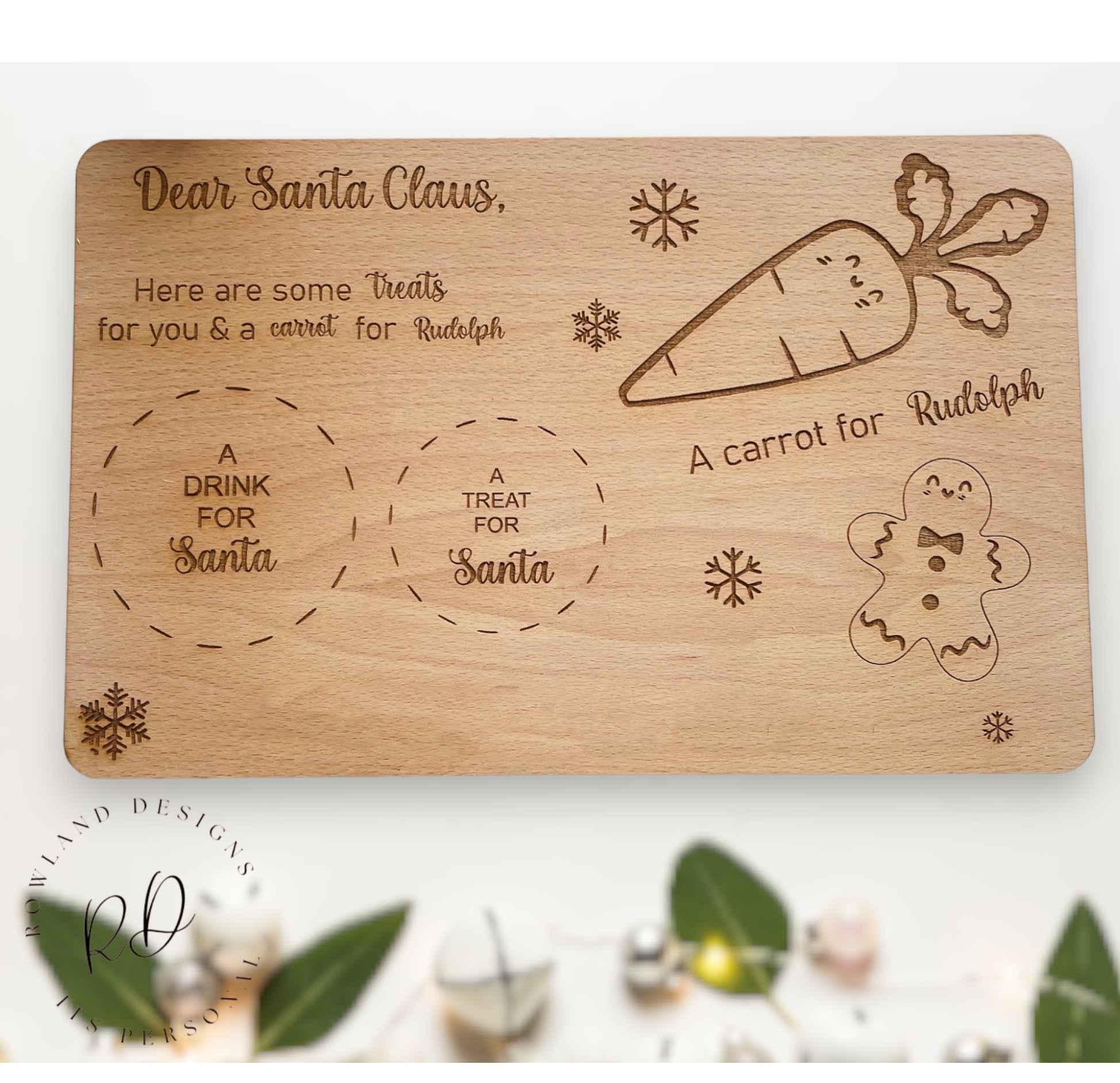 A wooden Christmas Eve board with spaces for a drink, treat, and carrot for Santa and Rudolf.