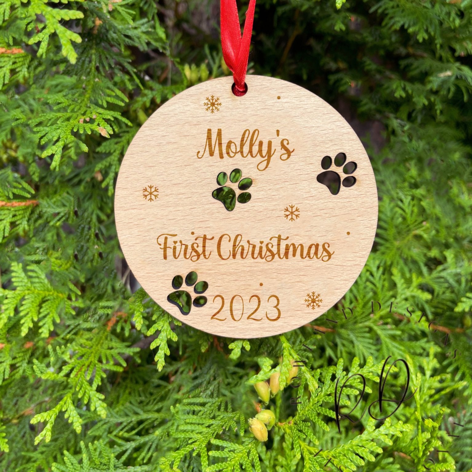 A wooden "Dog's First Christmas" ornament, custom engraved with the pet's name.