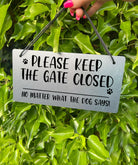 "Silver Laser-Engraved 'Please Keep the Gate Closed' Sign with Paw Print Illustration" Description: Close-up of a silver-colored acrylic sign with laser-engraved text that reads "Please Keep the Gate Closed, No Matter What the Dog Says." The sign features a cute paw print illustration, adding a playful touch.
