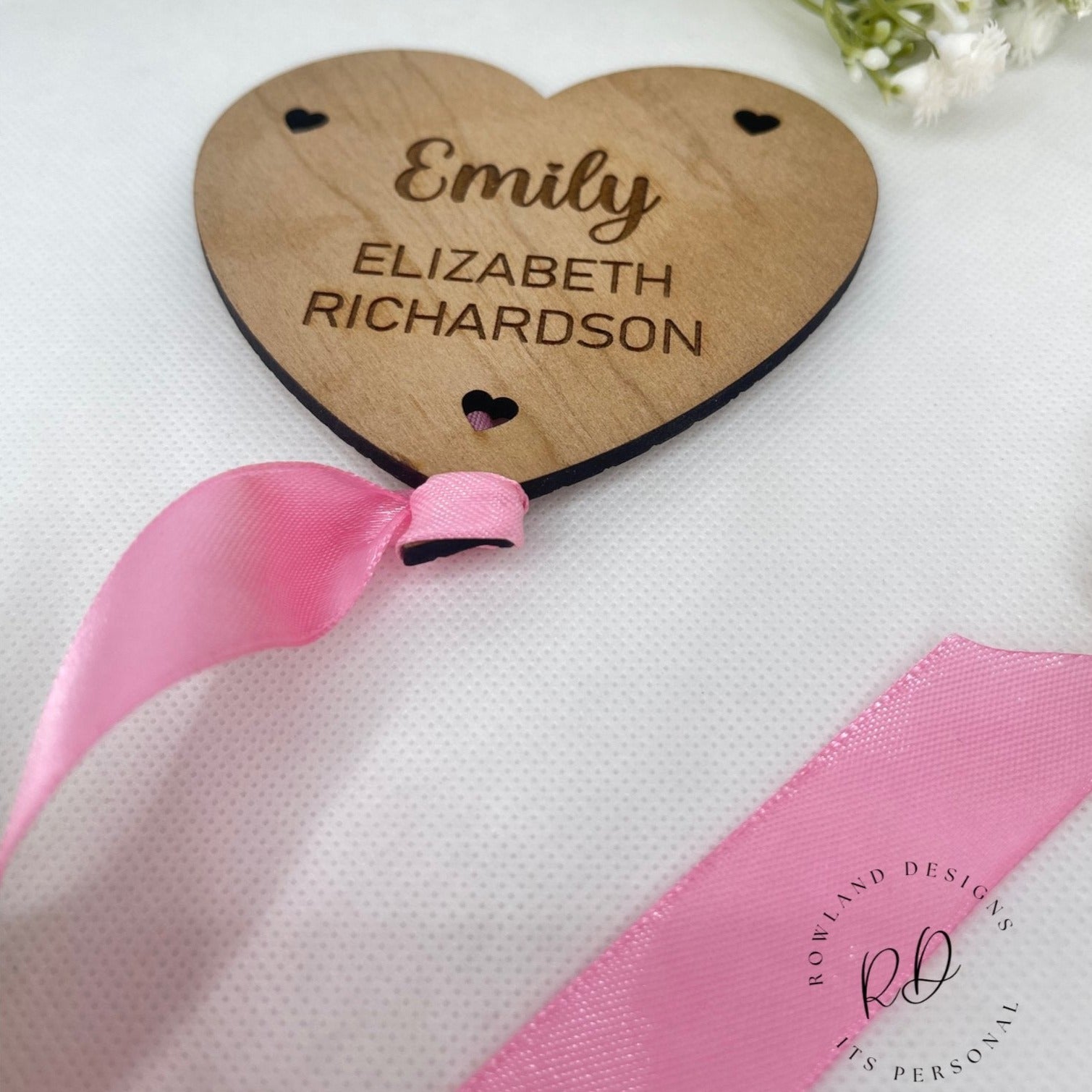 Close-up of an engraved plaque with a balloon and heart design and a new baby's birth information.