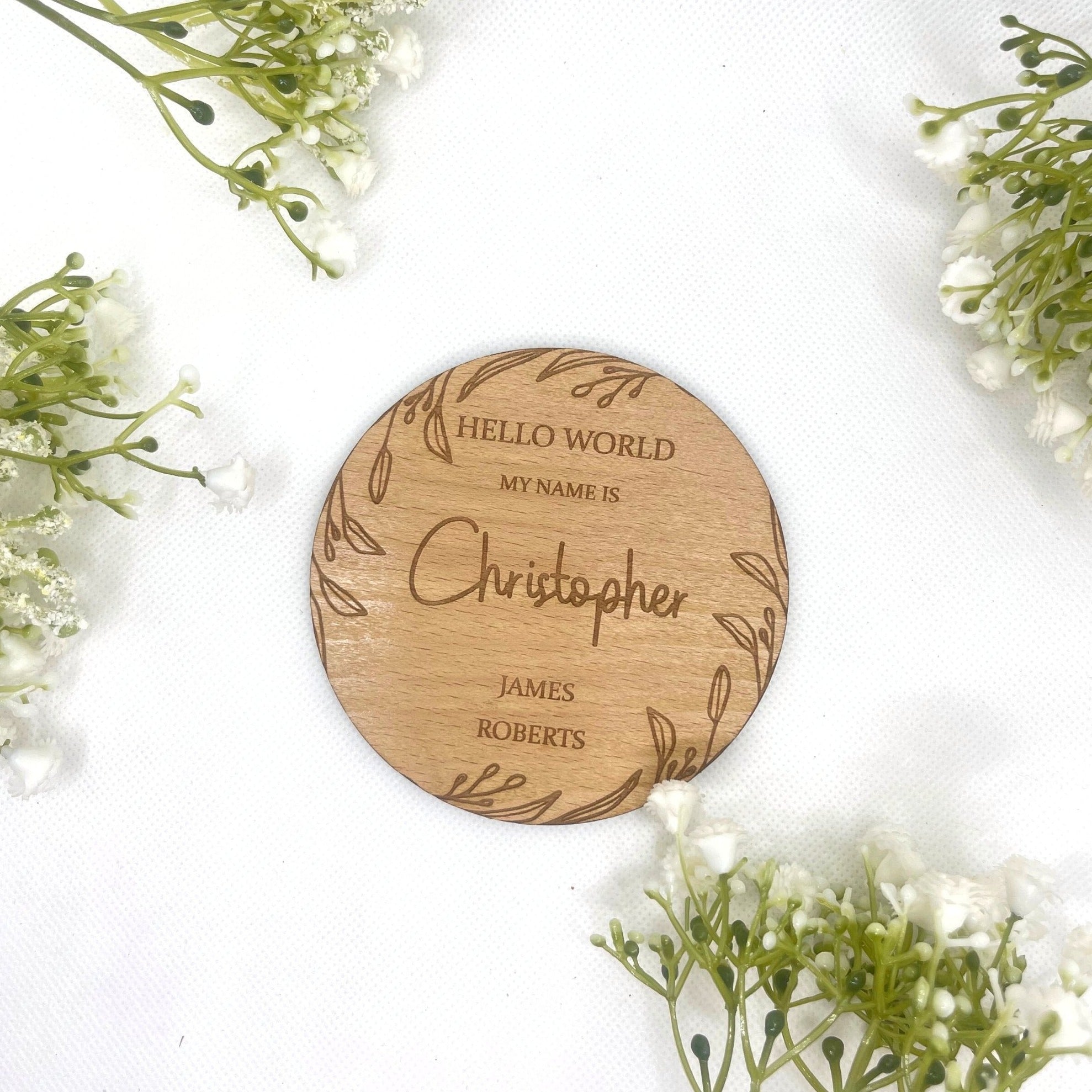 Close-up of an engraved plaque with a boho leaf design and a new baby's name.