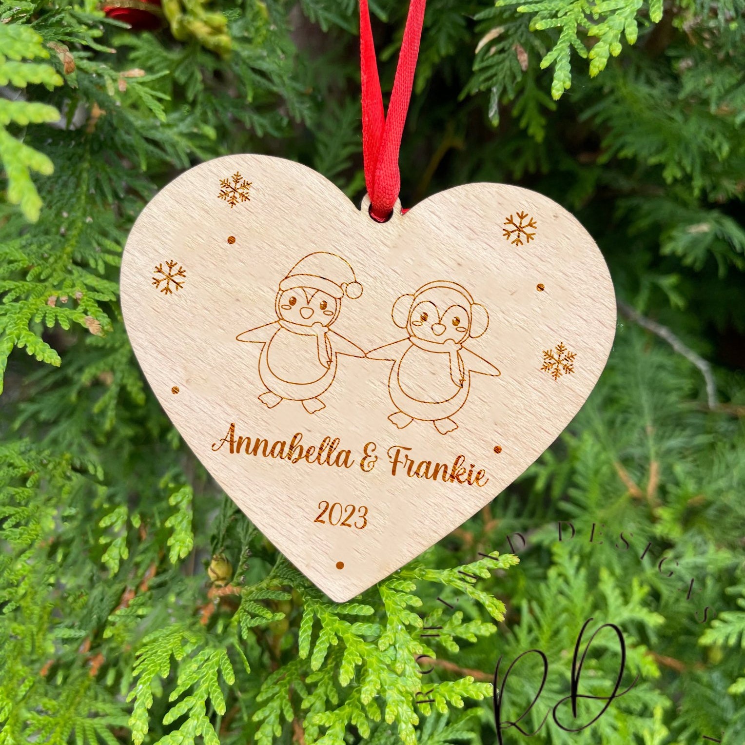 An engraved wooden Christmas gift for a couple, showing their names and the year.