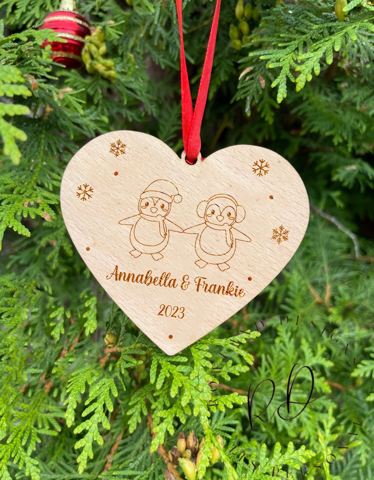 An engraved wooden Christmas gift for a couple, showing their names and the year.