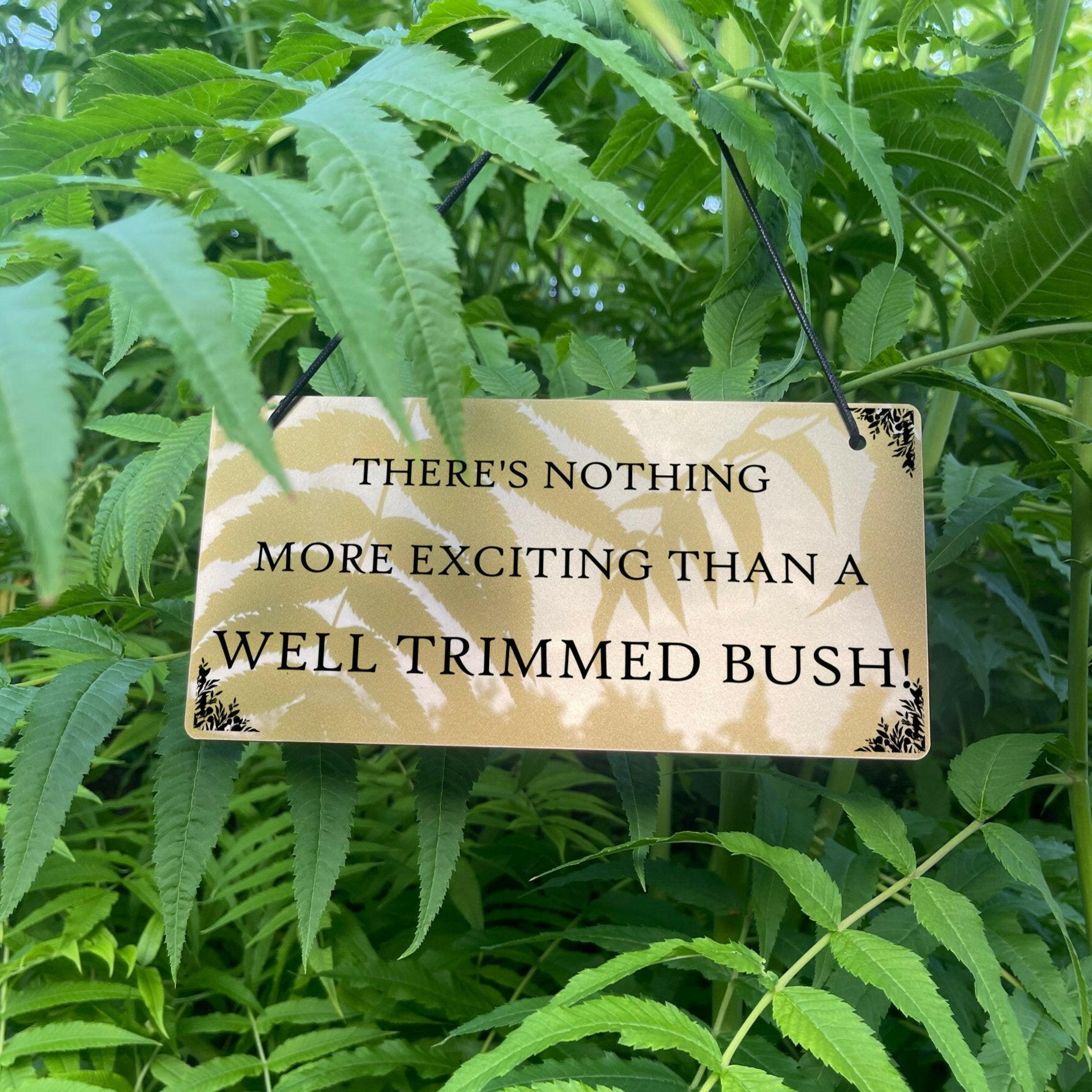 Decorative sign with humorous quote on a bush