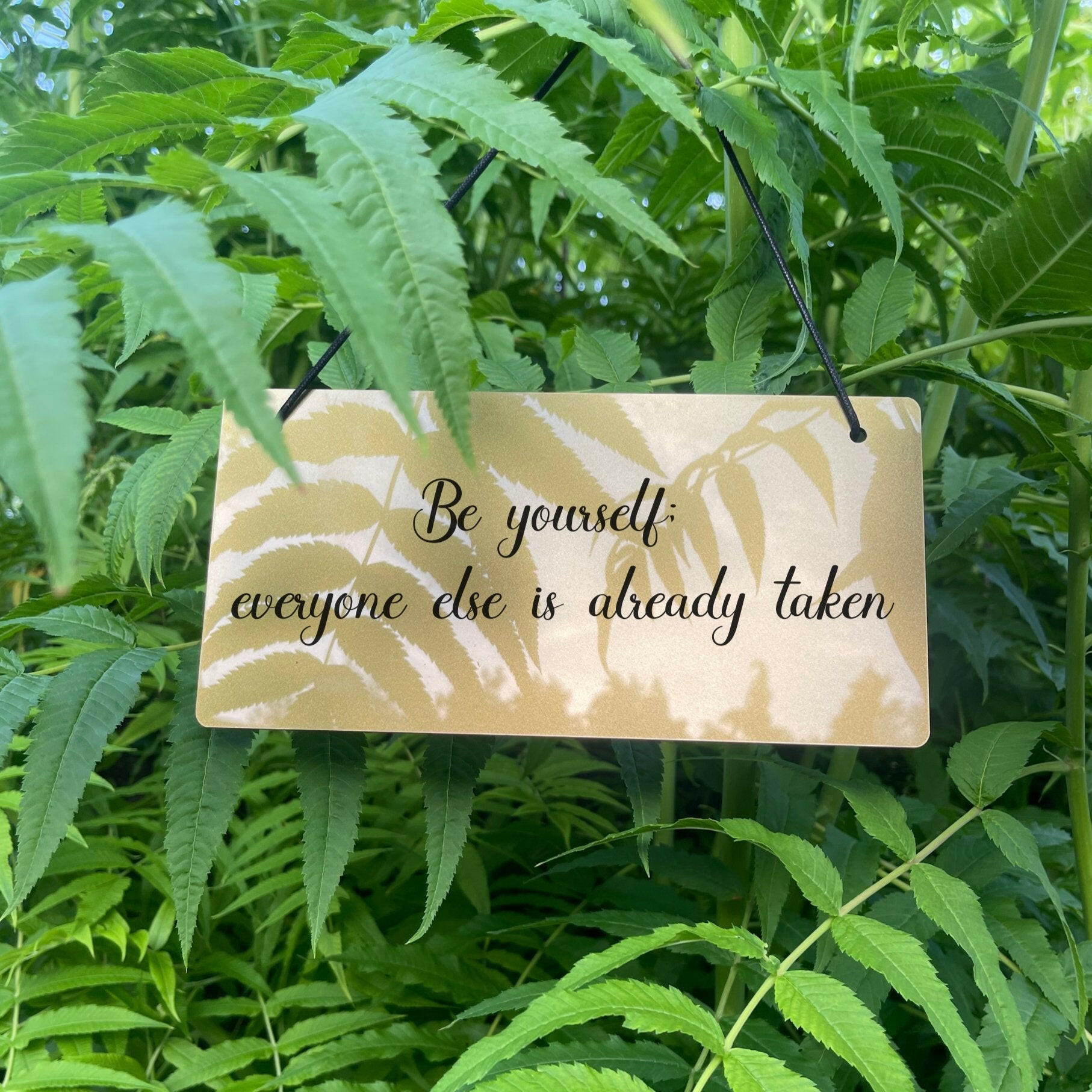 Inspirational home decor sign with a mirror finish, hanging on a wall.
