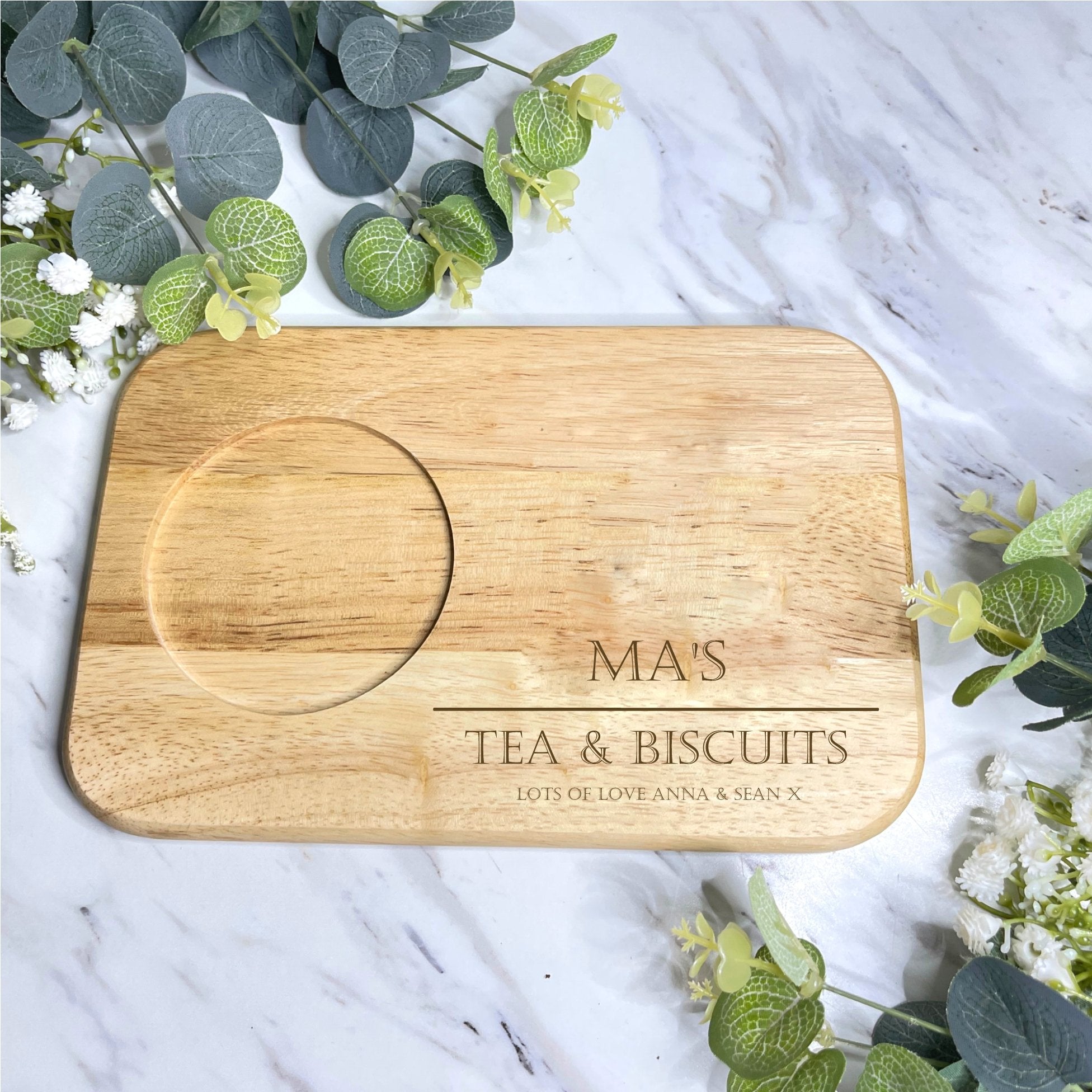 A Tea & Biscuit Board crafted from top-grade wood, ideal for gifting to someone who enjoys warm drinks and treats. Engraved with care, it's suitable for various occasions such as Mother's Day, birthdays, and Christmas. The board's dimensions are 23cm x 15cm x 1.5cm, perfect for hosting stylish afternoon teas.