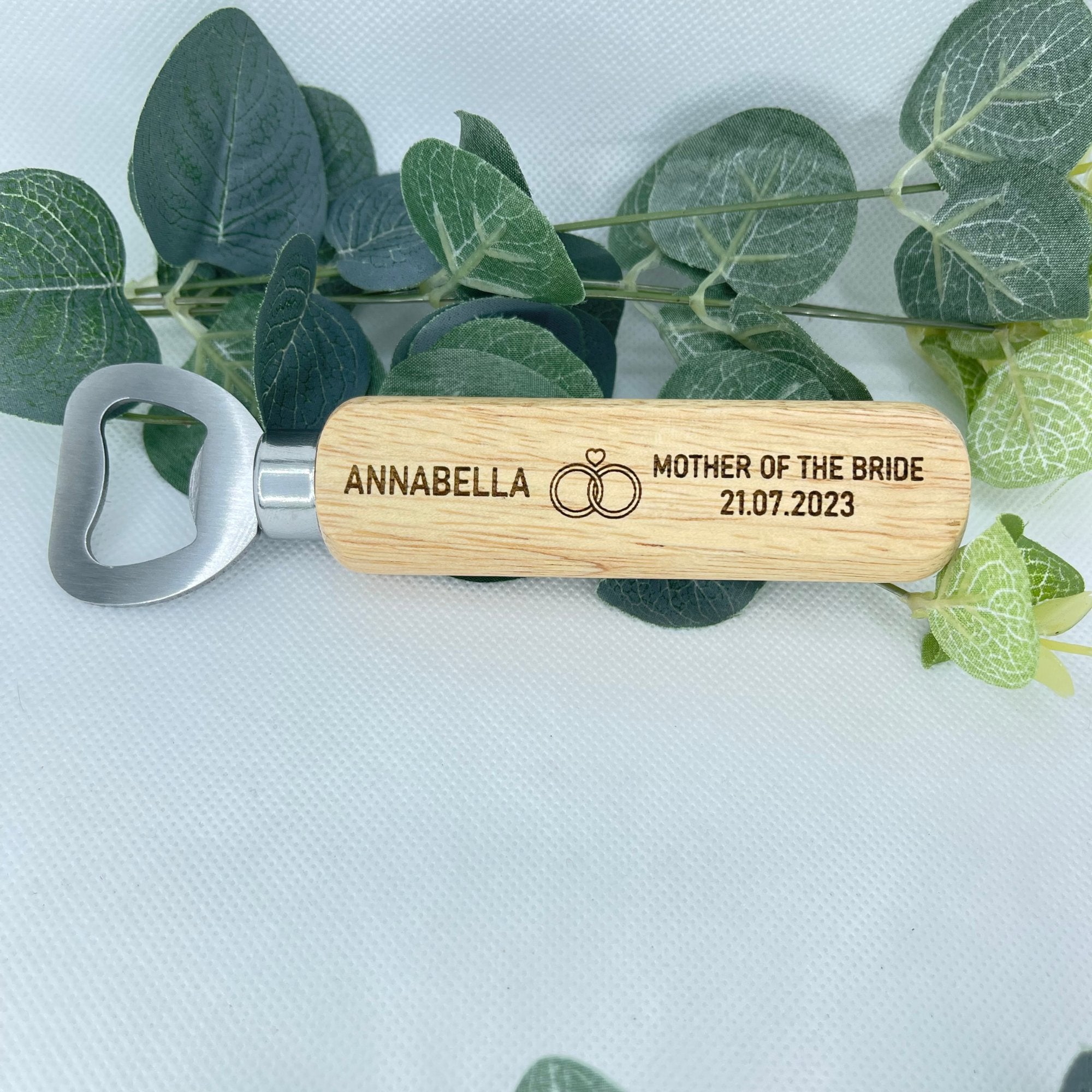Bottle opener personalise with name at the left hand side, right role of wedding & date under. in the middle there is a picture of two rings & a heart on top. Perfect for wedding gifts. Bridesmaids with a girly touch.