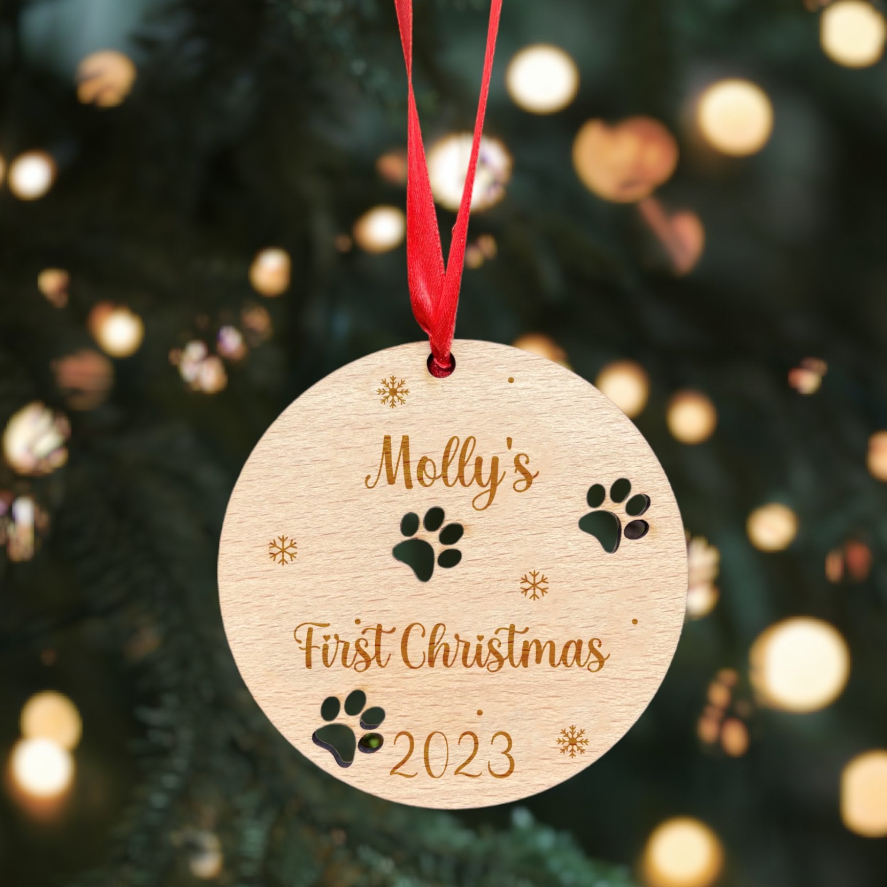 A personalised dog Christmas bauble for a "First Christmas" with an intricate paw print design.