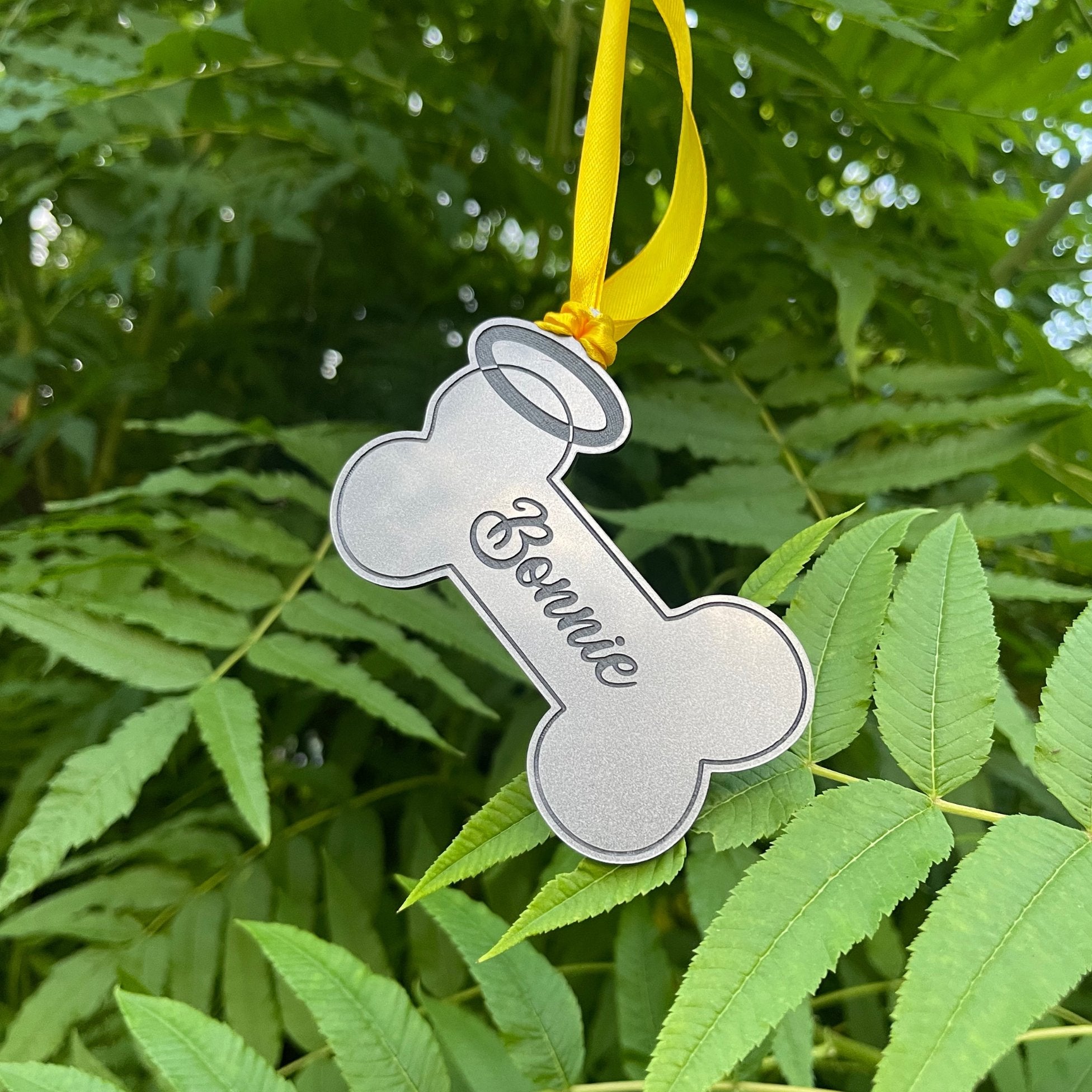 A personalised dog memorial gift, a bone-shaped keepsake with a halo and custom name.
