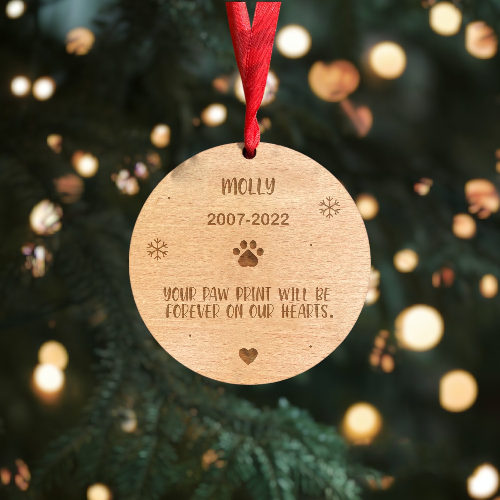 A personalised wooden heart decoration to remember a dog, with a custom name and a paw print.