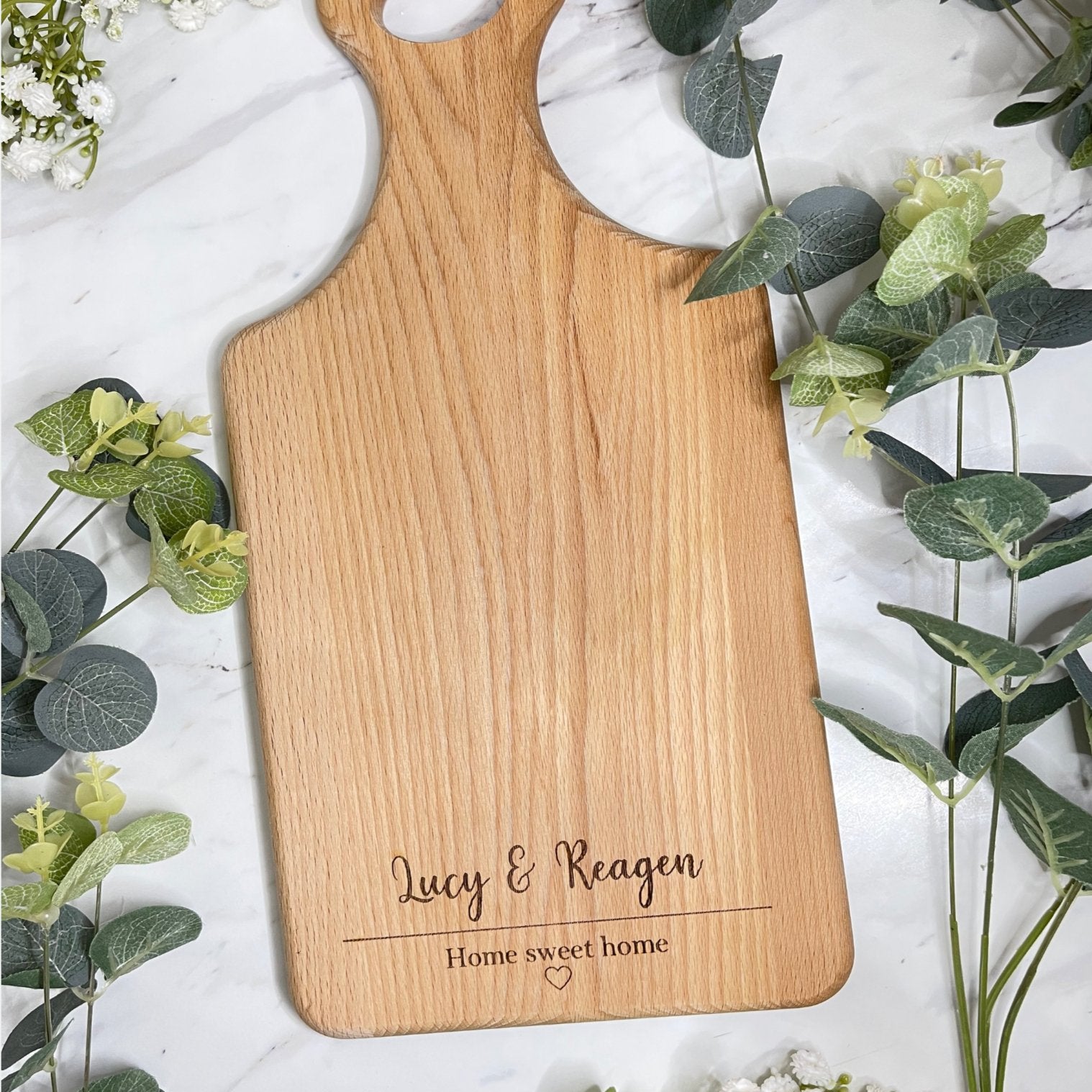 A personalised wooden serving board engraved with "Home Sweet Home," perfect as a housewarming gift.