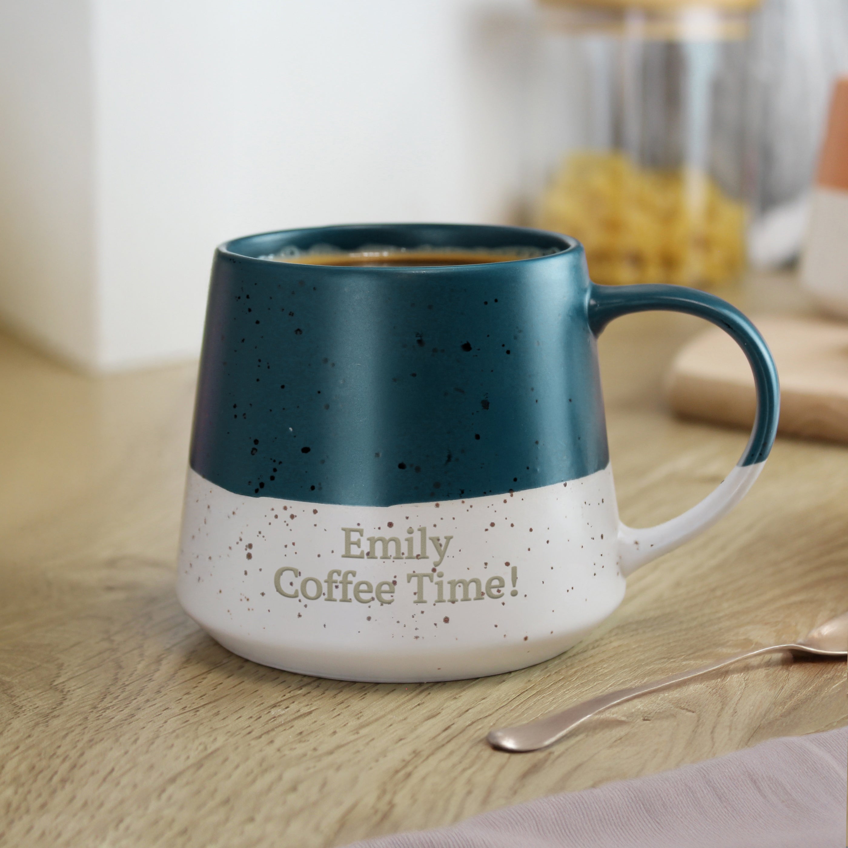 Blue and white speckled mug with 'Emily Coffee Time!' text on a wooden surface.