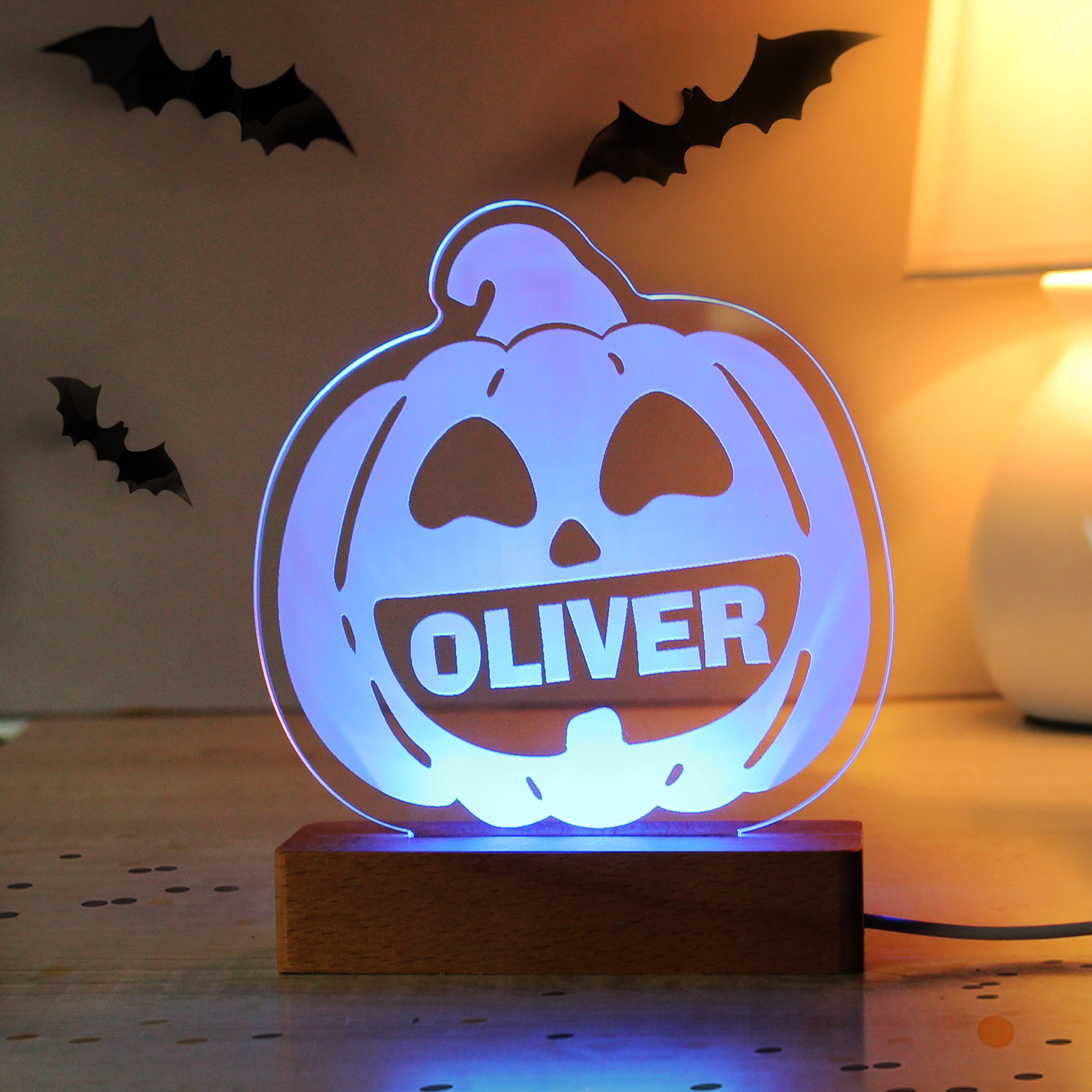 Halloween-themed lamp with 'OLIVER' on a wooden base, surrounded by decorative bats.