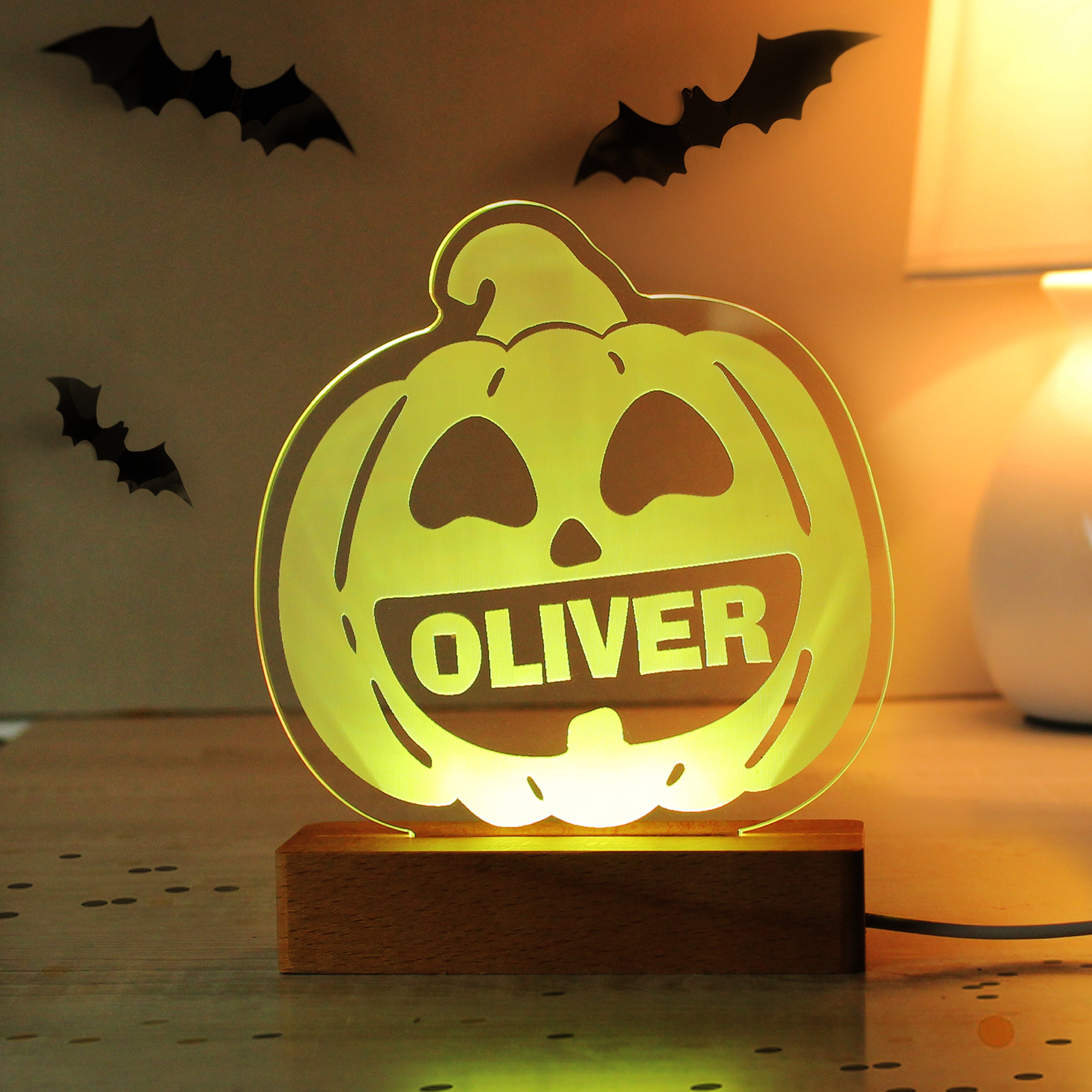 Halloween-themed lamp with 'OLIVER' on a wooden base, surrounded by decorative bats.