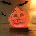 Halloween-themed pumpkin light with 'OLIVER' on a wooden base, surrounded by bats.