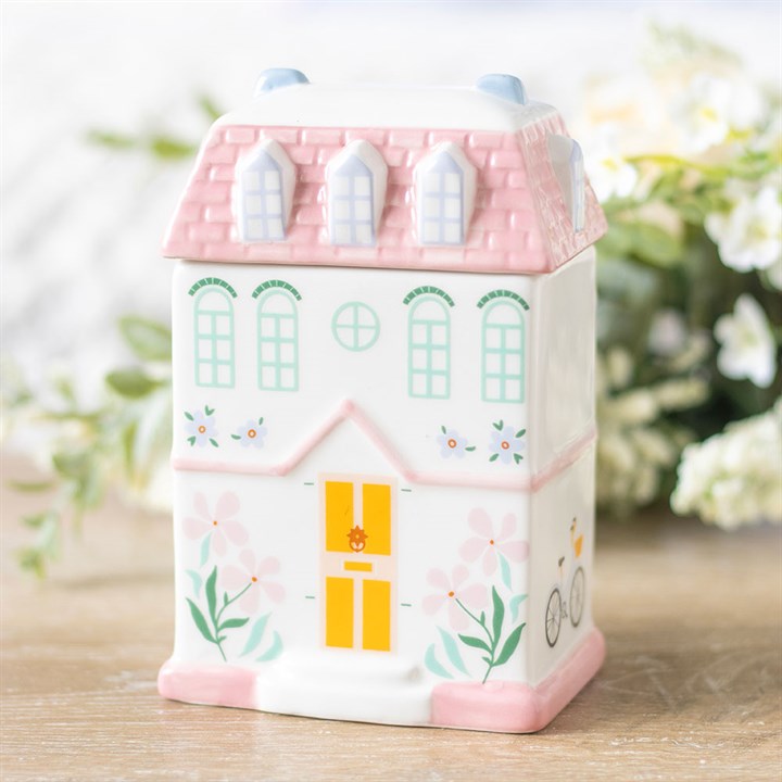A pastel pink house-shaped wax melter and oil burner, perfect for home decor and relaxation. Simply add your favorite wax melts or essential oils and enjoy the soothing aroma.