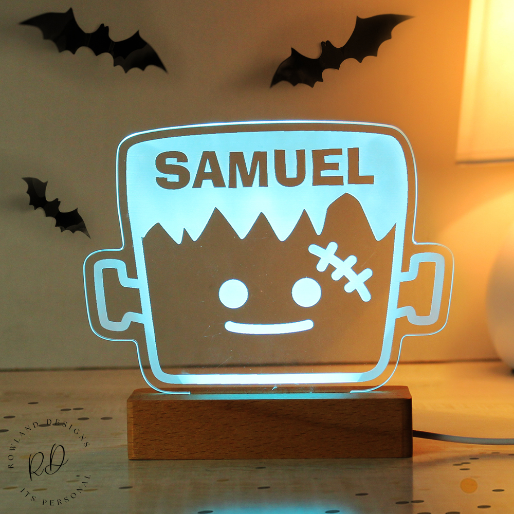 LED sign shaped like a Halloween-themed container with 'SAMUEL' on top, glowing in a dimly lit room.