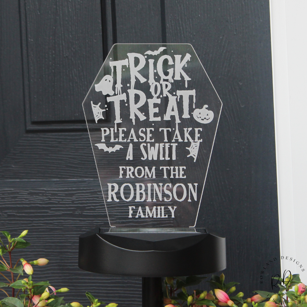 Halloween-themed acrylic sign with 'Trick or Treat' message on a black background