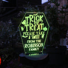 Glowing Halloween-themed sign with personalised text in a dark outdoor setting.