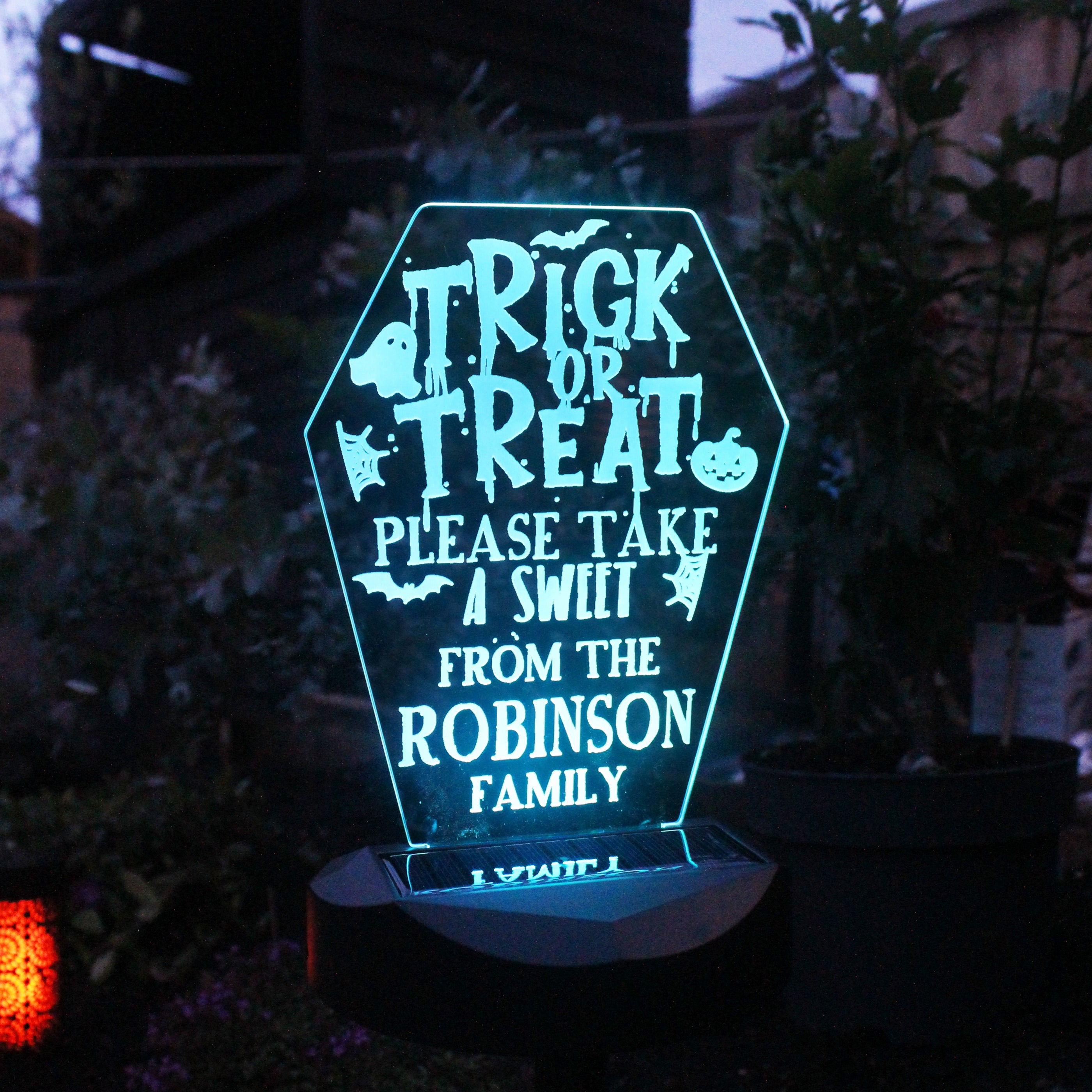 Halloween-themed LED sign with personalized text in a dark outdoor setting.