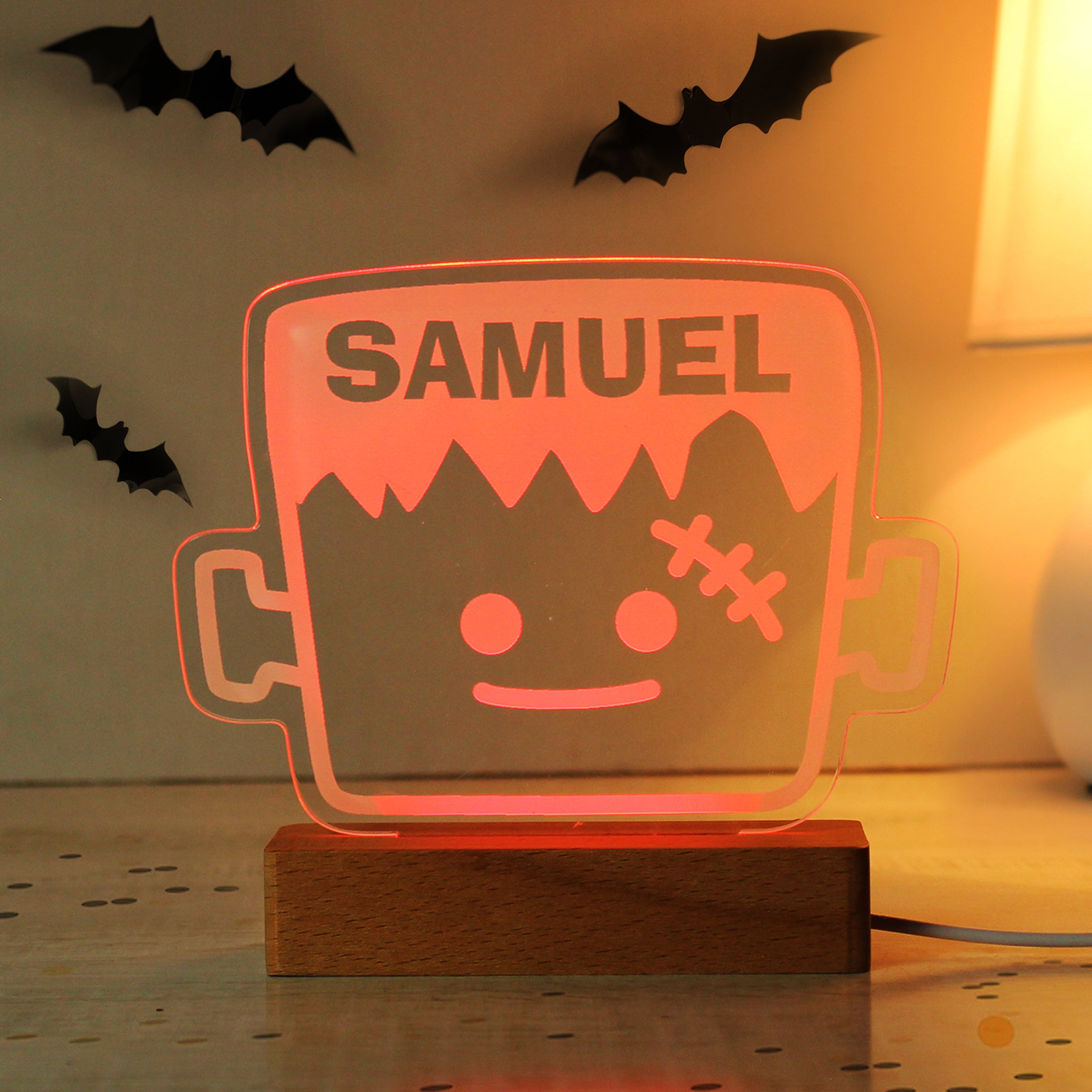 Halloween-themed lamp with 'SAMUEL' on a wooden base, surrounded by decorative bats.