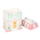 A delicate vintage rose-colored ceramic oil burner with a house design, featuring a removable top for easy wax melt or oil placement. Ideal for adding warmth and fragrance to any space.