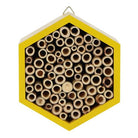 Bee hotel hanging from a tree or fence, ready to attract pollinators.