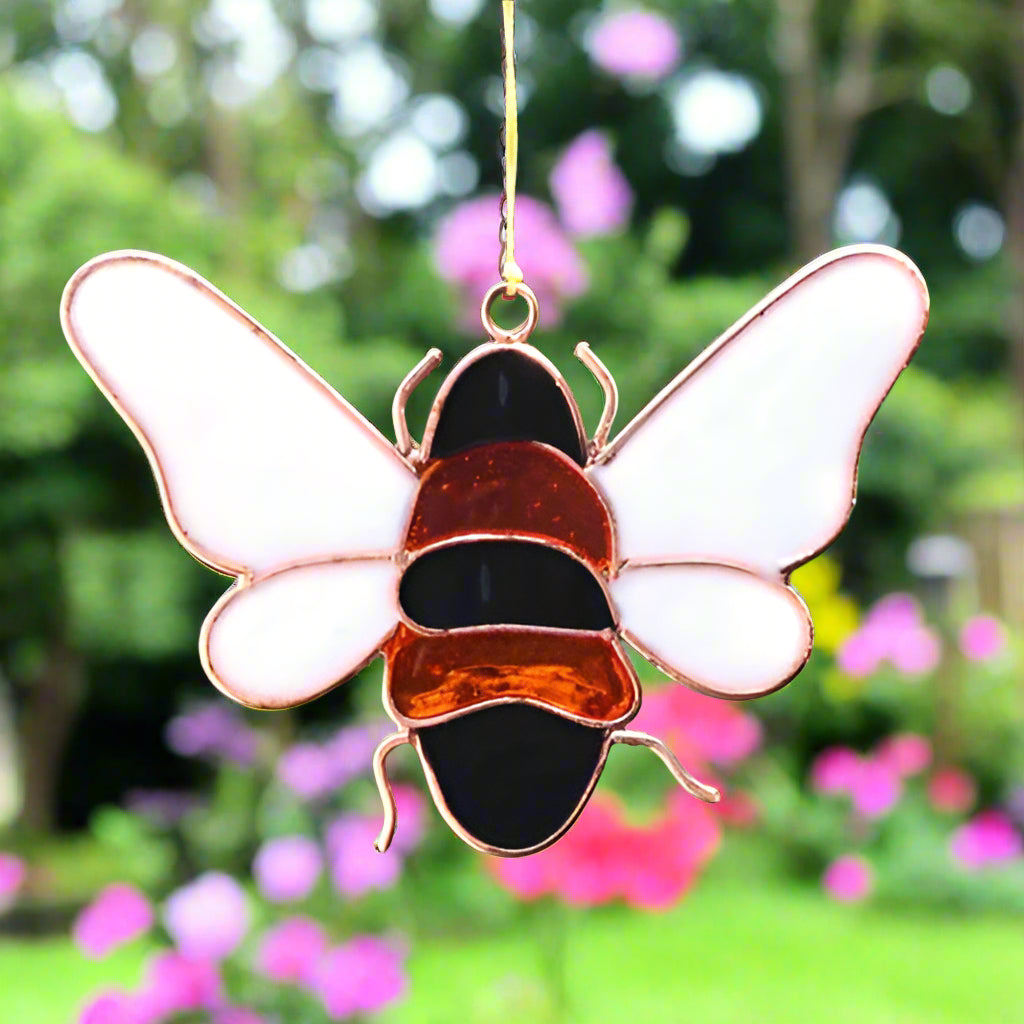 Bee suncatcher hanging in a window, catching the light beautifully.