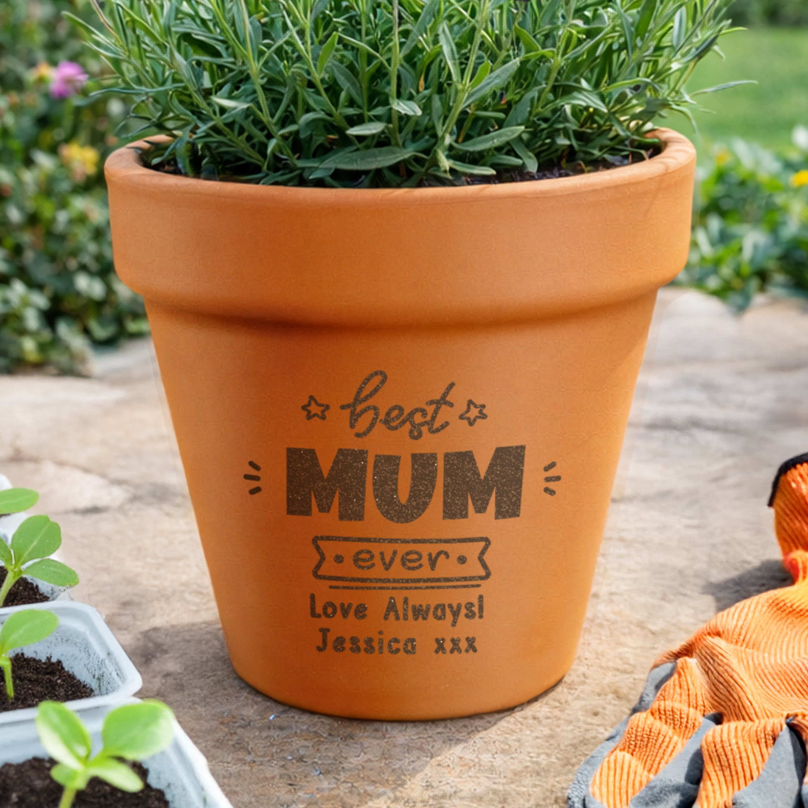 Terracotta pot with engraved message 'Best Mum ever, Love Always Jessica xxx' on a wooden surface.