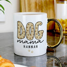 White mug with 'DOG mama HANNAH' text on a marble surface