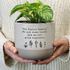 Person holding a potted plant with personalised text on a neutral background