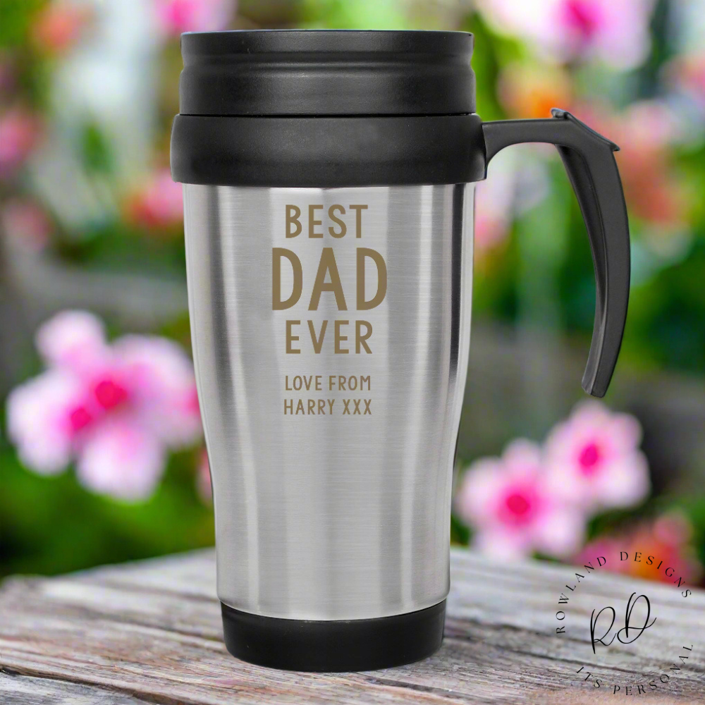 Close-up of a stainless steel thermal mug showing engraved custom message and practical screw-top lid.

