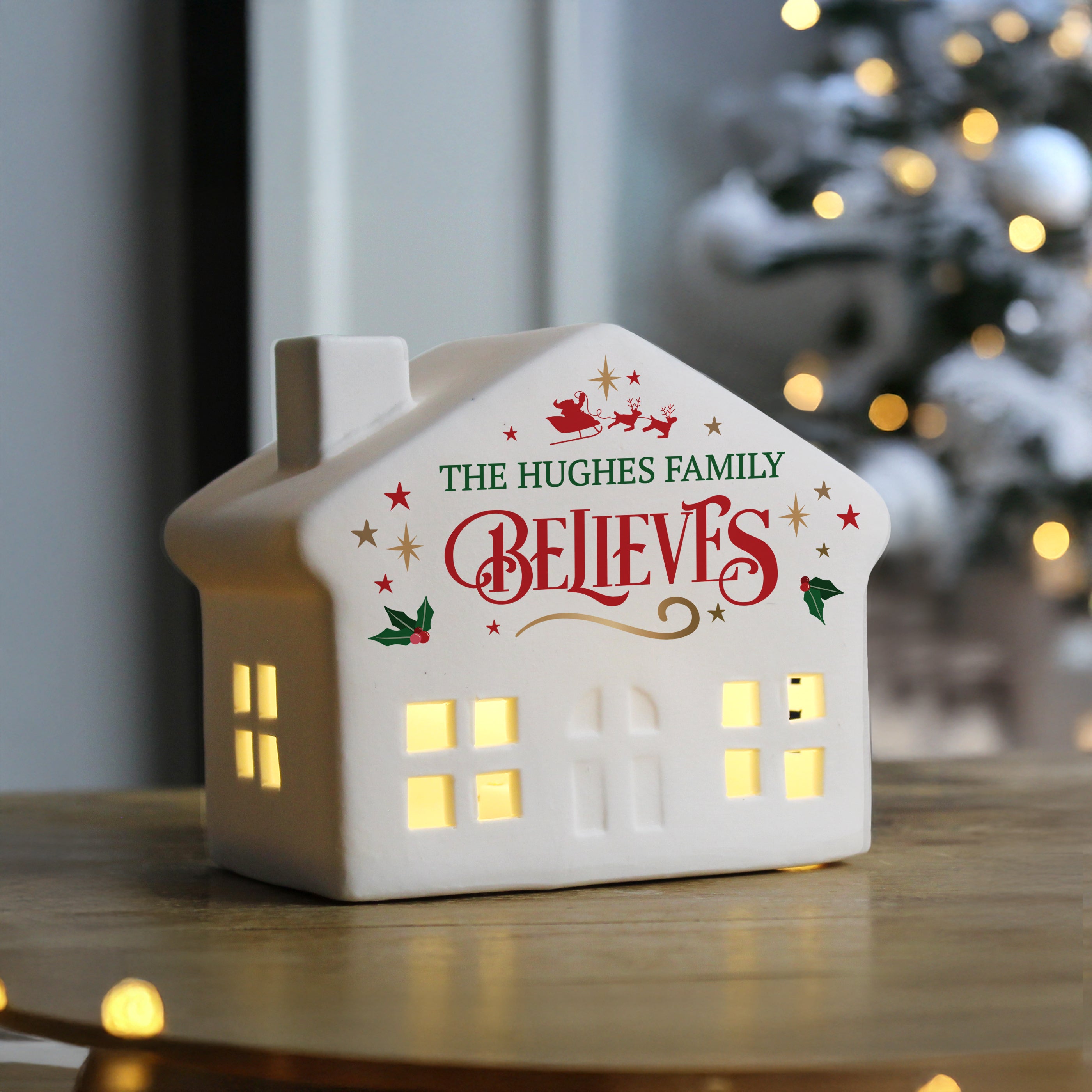 Close-up of the charming LED light-up Christmas house creating a warm festive glow.