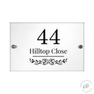 Modern acrylic house sign with leafy pattern displayed on wall