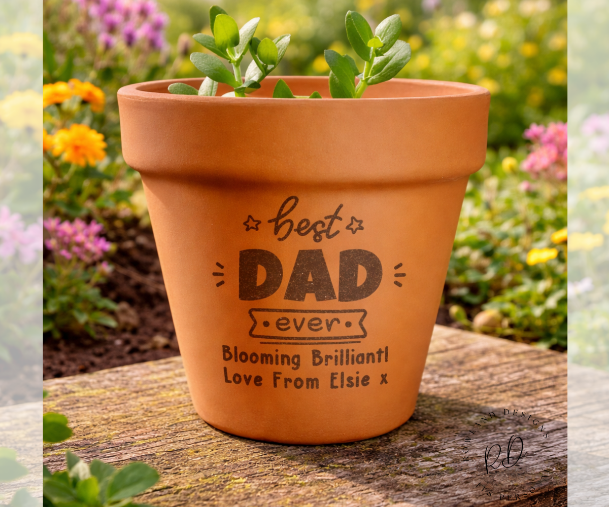 Terracotta pot with engraved message on a wooden surface with a garden background
