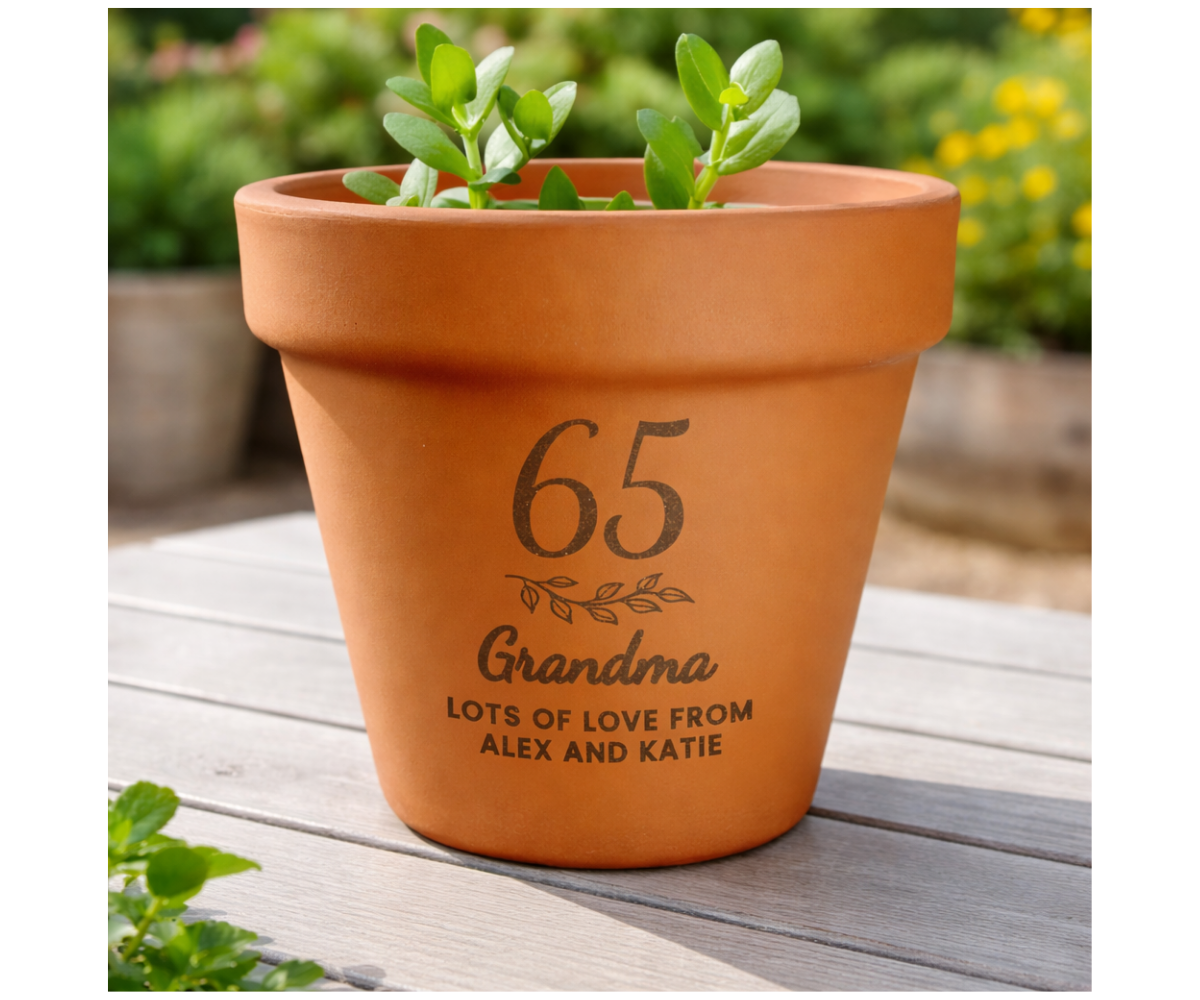 Terracotta pot with engraved text on a wooden surface