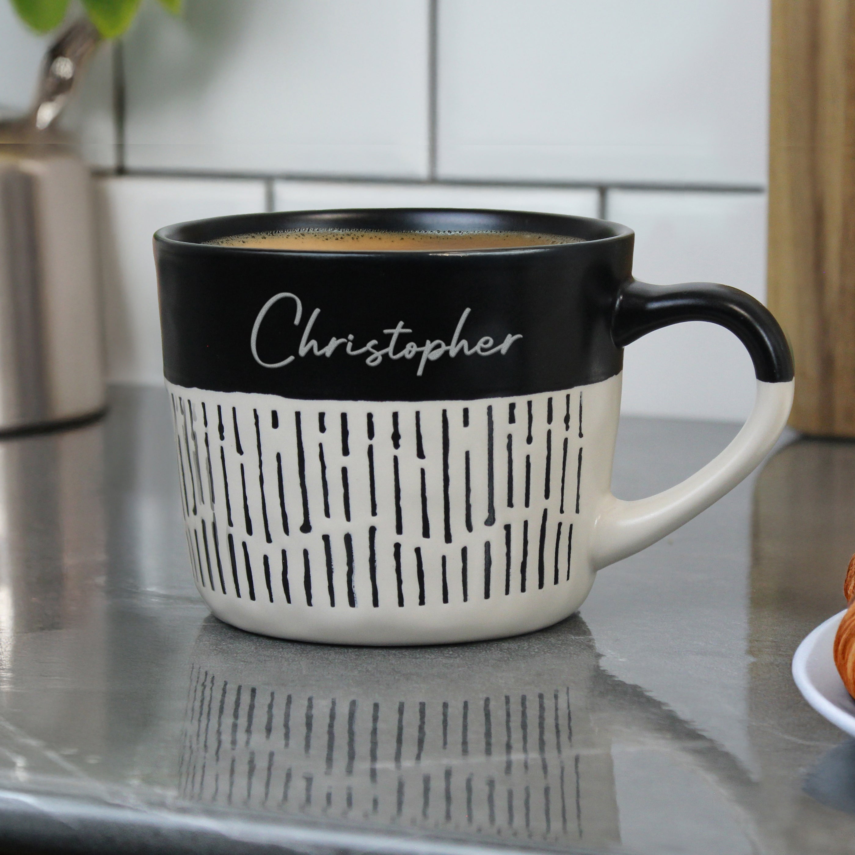 Black and white mug with 'Christopher' on a kitchen counter
