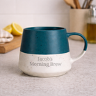 Personalised blue speckled ceramic mug with custom text on a kitchen counter