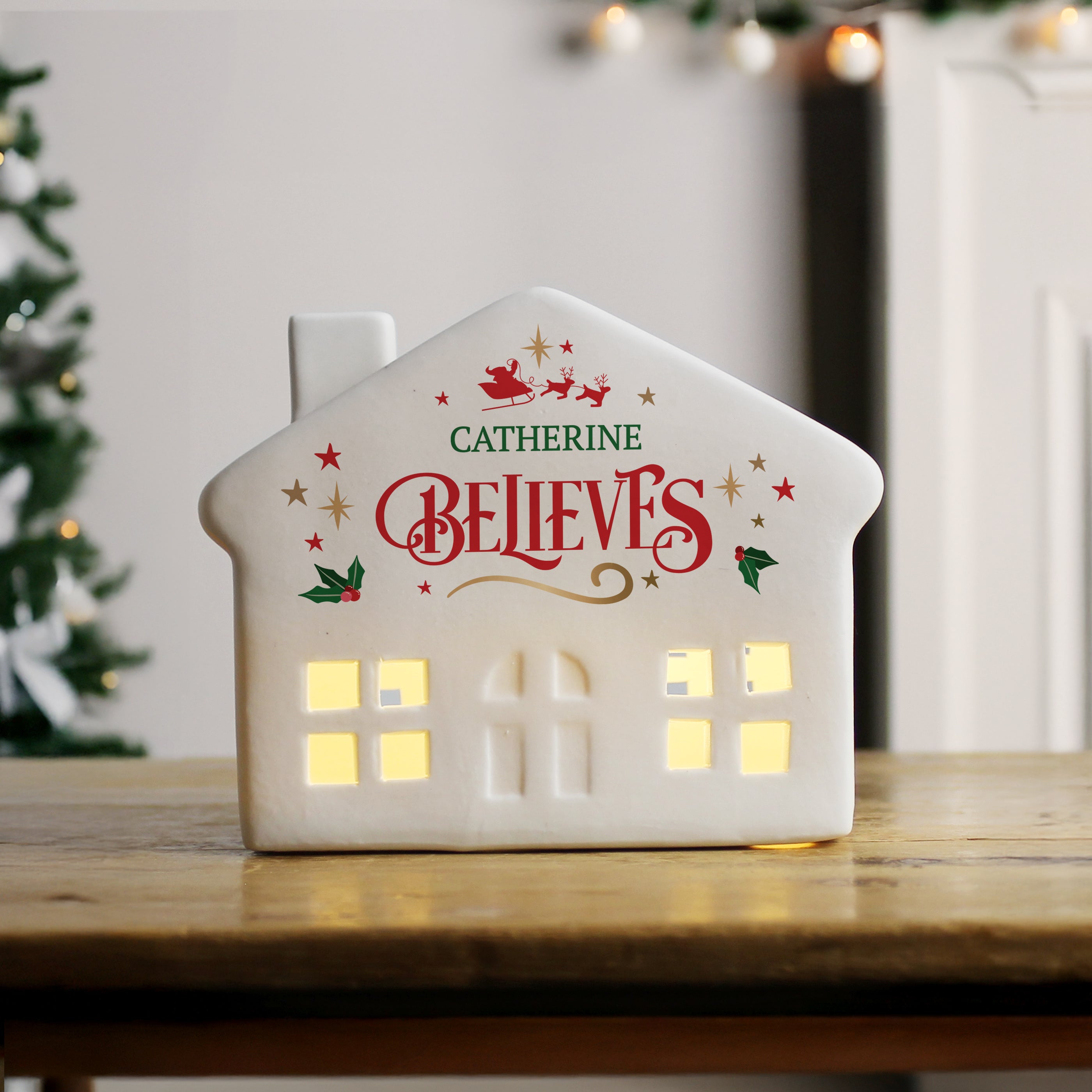 Full view of the personalised ceramic LED light-up house Christmas decoration.

