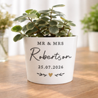 Potted plant with personalized pot on a wooden surface