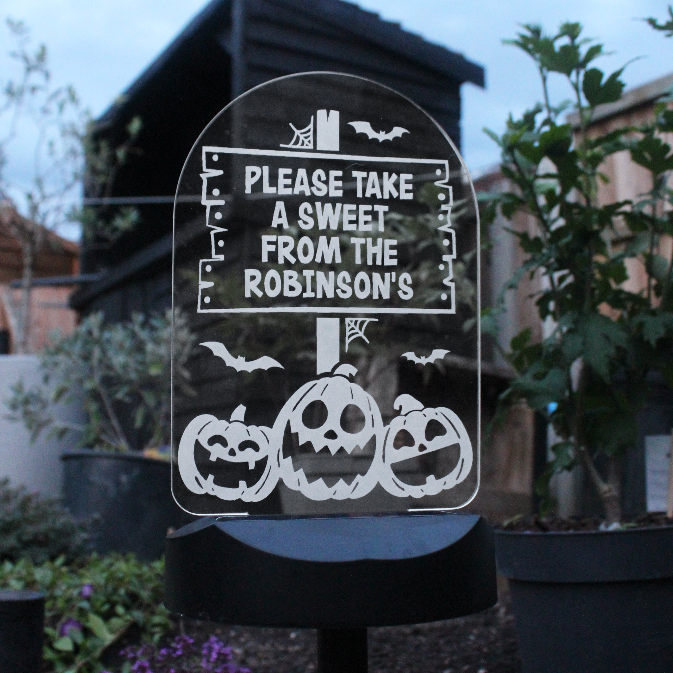 Halloween-themed sign with pumpkins and text 'Please take a sweet from the Robinsons' on a stand outdoors.